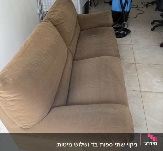 ספה חומה עם ציוד ניקוי ברקע